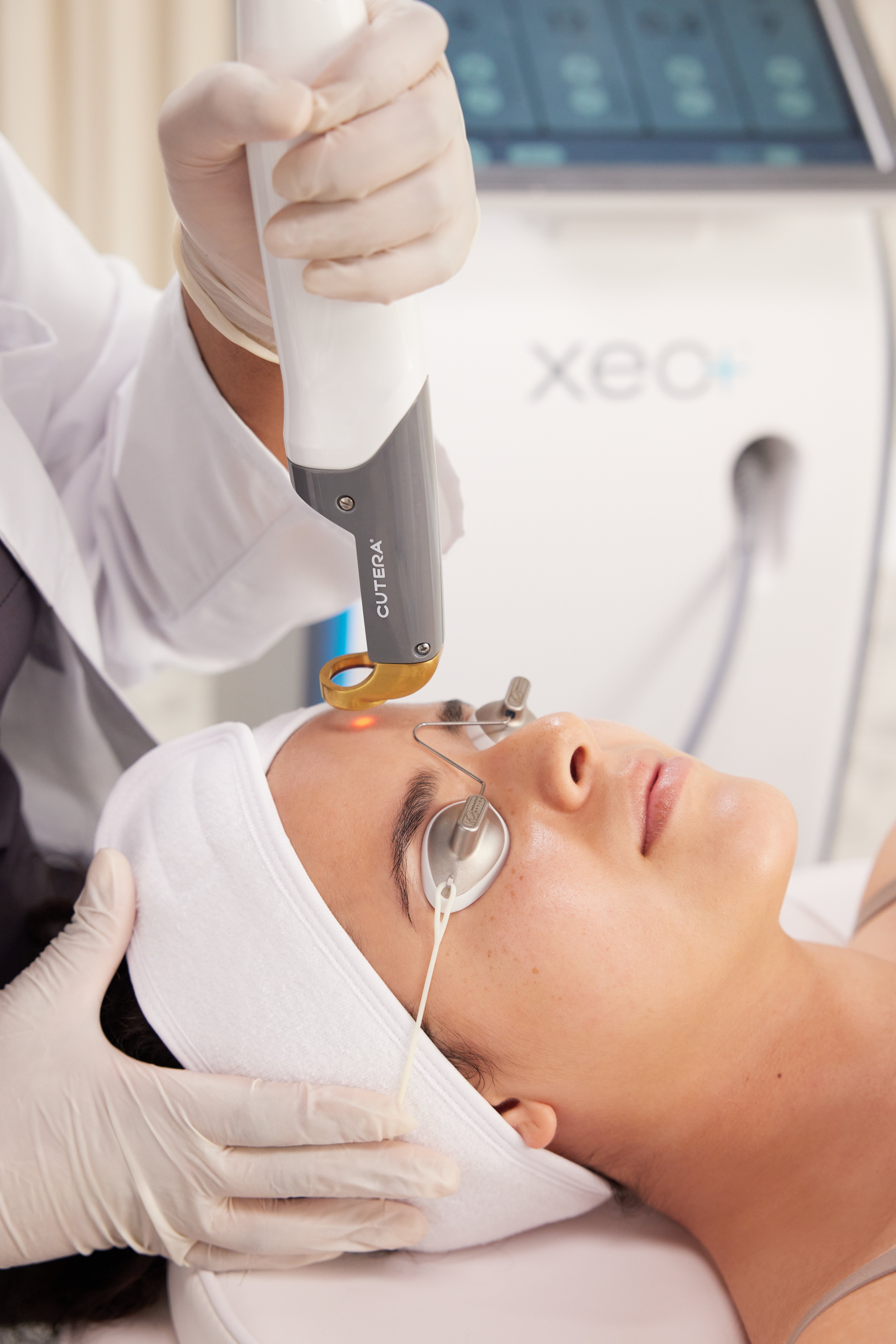 Cutera handpiece treating a client's forehead